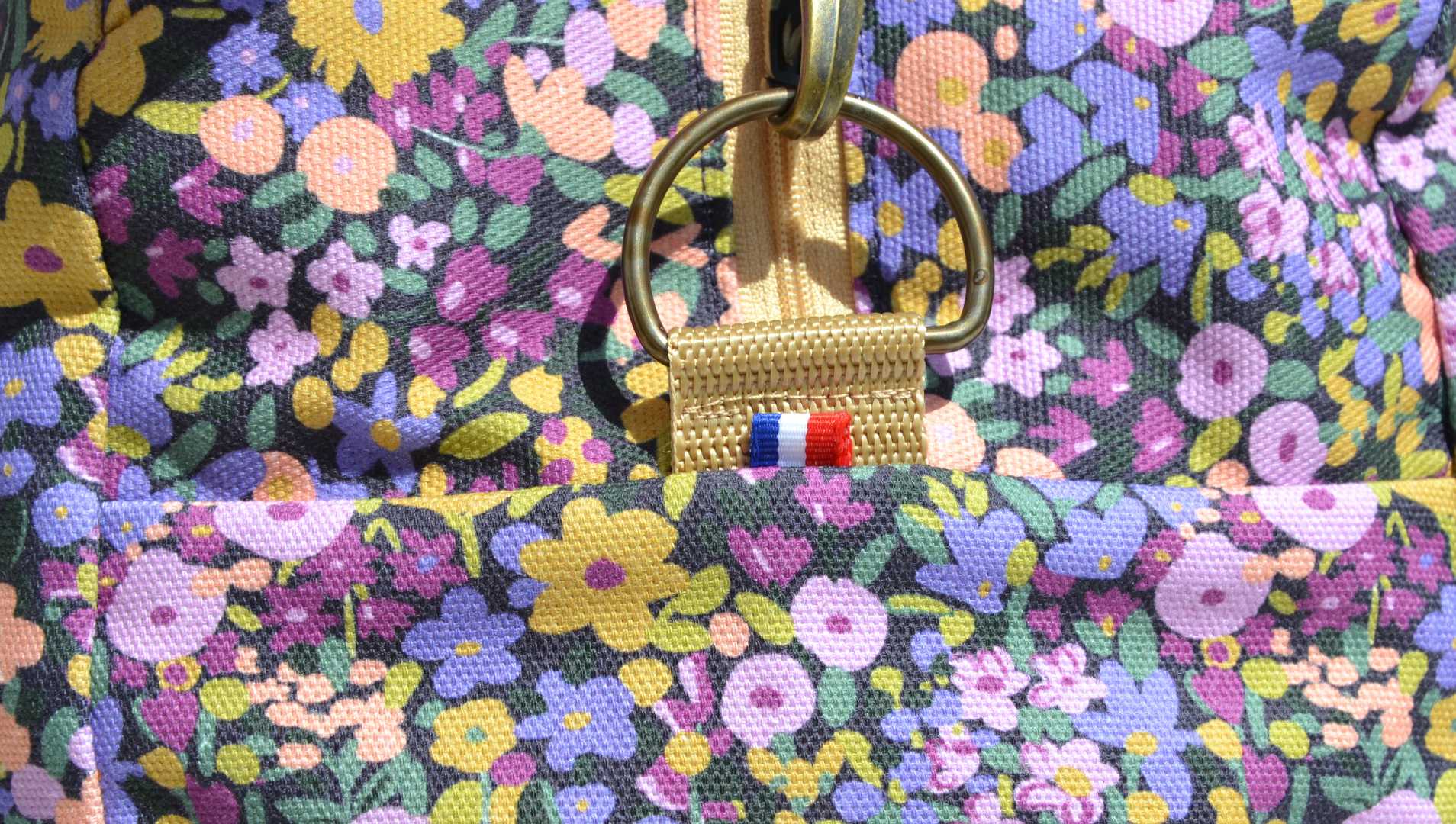 détail d'un sac week-end sur un ruban tricolore pour montrer la fabrication française