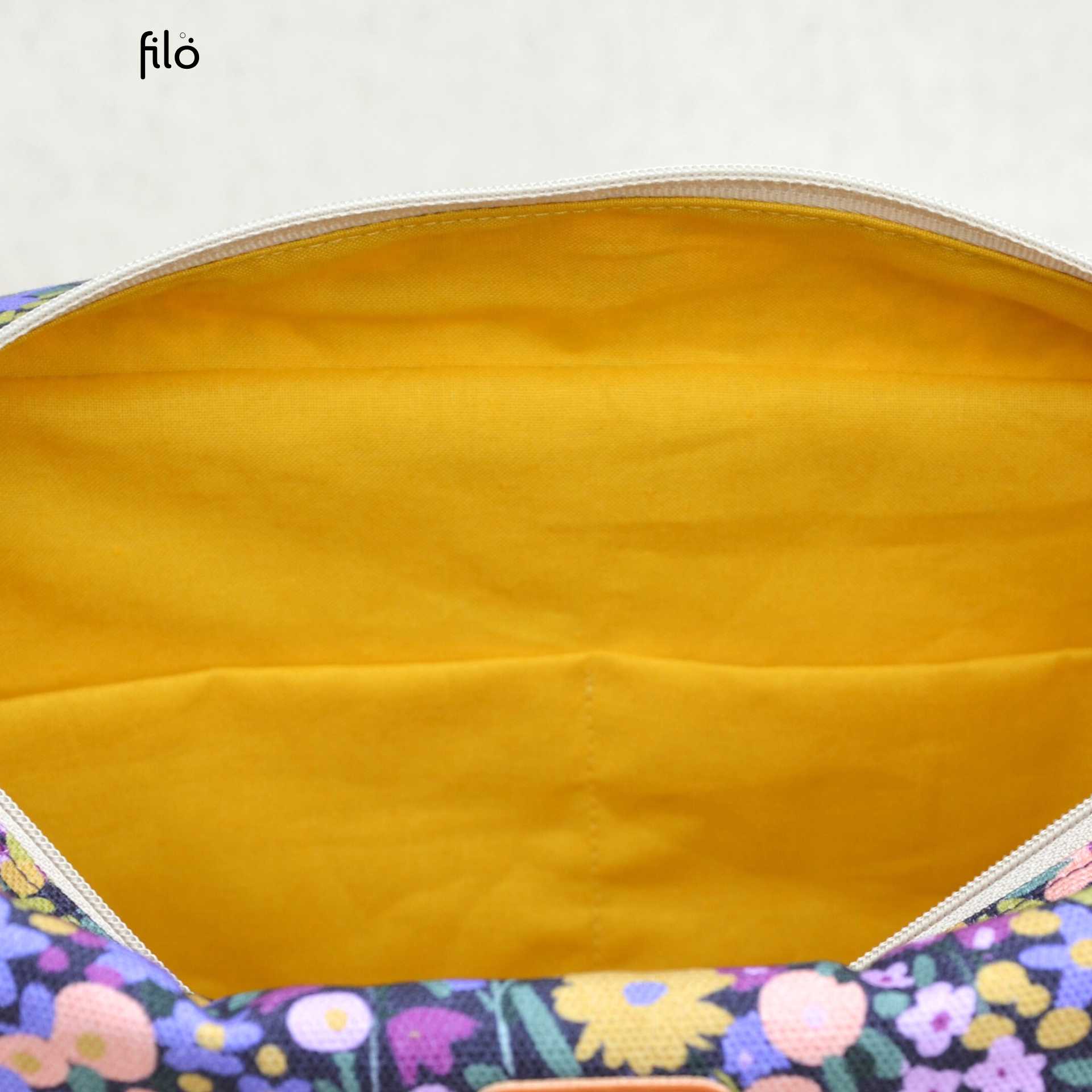 Vue intérieure de la trousse de maquillage artisanale avec doublure jaune et quatre poches de rangement